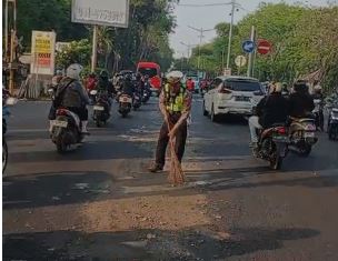 Sigap! Anggota Polsek Buduran Tutup Ceceran Solar Licin Demi Keselamatan Pengendara